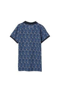 Polo à manches courtes en bleu marine avec un motif floral en bleu, blanc et beige. Dispose d'un col sombre et d'un tissu texturé.
