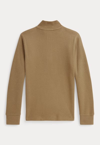 Tan long-sleeve turtleneck sweater made of ribbed knit fabric. Features a high collar and fitted sleeves. Texture appears soft and stretchy.