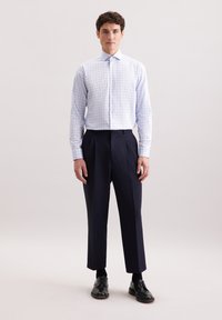Camicia da uomo a trama a quadri blu chiaro con colletto a punta, abbinata a pantaloni a pieghe blu navy scuri e scarpe stringate nere.