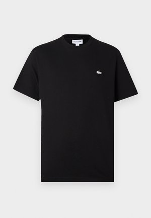 Tricou din bumbac negru cu guler clasico și mâneci scurte. Logo-ul alb subtil Lacoste pe partea stângă a pieptului. Textură netedă.