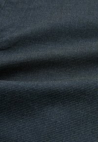 Donkere gestructureerde stof met een klein ruitpatroon in tinten blauw en grijs, met een zachte, gladde afwerking en een lichte glans.