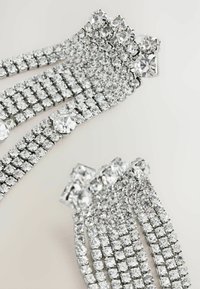 Accesorii de păr din argint cu mai multe rânduri de strasuri clare, tăiate rotund, într-o montură cu vârfuri, creând un aspect strălucitor și texturat.