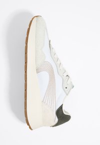 Sneakers bianche realizzati con materiali in camoscio e rete, suola in gomma e dettagli di cucitura unici. Profilo laterale con design della punta arrotondata.