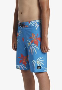 Plave kupaćice s tropskim cvjetnim uzorkom u crvenoj, žutoj i zelenoj boji. Podesivi struk s crnom uže. Quiksilver oznaka.