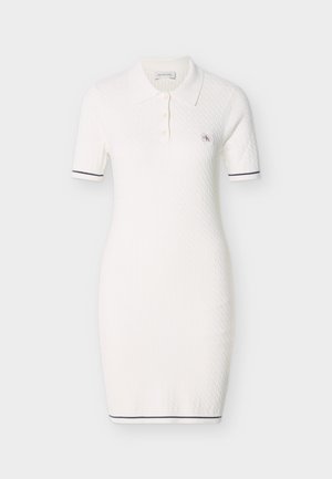 Rochie polo albă tricotată cu mâneci scurte, având un guler și un mic patch cu logo. Accentuata cu dungi bleumarin la tivul mânecilor.