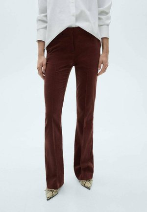 Brown flared trousers made from soft material, featuring a fitted waist and subtle vertical seams, paired with snake-patterned pointed heels.