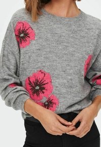 Grauer gestrickter Pullover mit großen rosa Blumenmustern und braunen Mittelpunkten, gerippten Bündchen und rundem Halsauschnitt.
