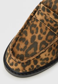 Leopard print suede loafers with a rounded toe, black rubber sole, and a smooth stitching detail along the edges.