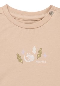 Beige Baumwollhemd mit rundem Ausschnitt, Druckknopf und einem bedruckten Design mit einer Schnecke sowie Blättern in grünen und lila Farbtönen.