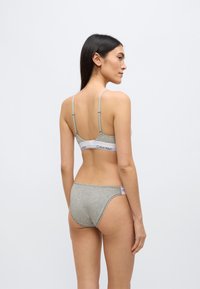 Γκρι βαμβακερό σουτιέν και σετ εσώρουχο, με λεπτές ράντες στους ώμους, φαρδιά ελαστική μέση με λωρίδα λογότυπου και λεία υφή.