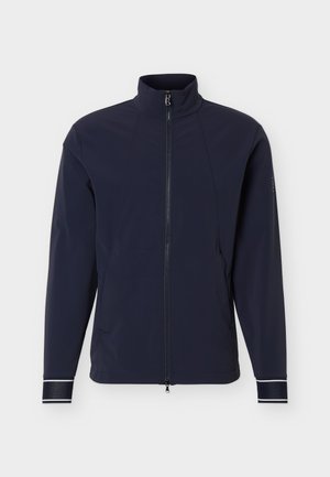 Ελαφρύ μπουφάν σε ναυτικό μπλε χρώμα με πλήρη φερμουάρ μπροστά, όρθιο γιακά, μακριά μανίκια και ανακλαστικές λεπτομέρειες στα μανίκια.