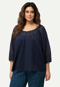 Blusa leggera di colore blu navy con scollo a barchetta e maniche 3/4, caratterizzata da un tessuto testurizzato e una vestibilità morbida.