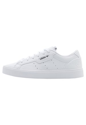 Bílá nízká teniska Adidas se šněrováním, perforovanými bočními panely, logem na straně a vyraženým detailem na patě.