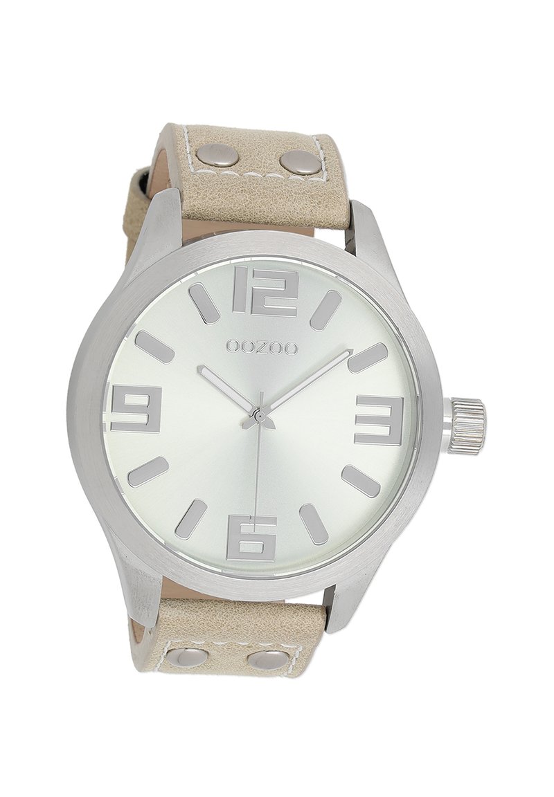 Montre en métal argenté avec un cadran rond, bracelet en cuir beige, grands chiffres arabes et un design minimaliste avec des accents métalliques.