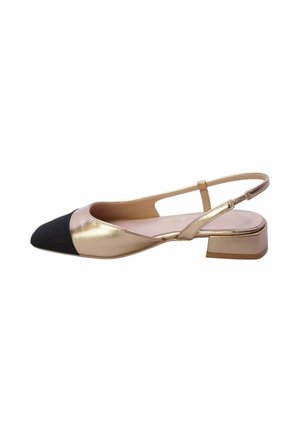 Scarpa slingback in metallo dorato con punta nera appuntita, tacco basso a blocchetto e cinturino regolabile su sfondo bianco.