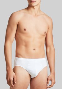Slip in cotone bianco con un design aderente. Presentano una texture liscia, una vita elastica e dettagli di cucitura minimi.