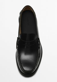 Black leather loafer with a smooth finish, seam detailing, and a raised accent band across the front. Minimalist design and rounded toe.