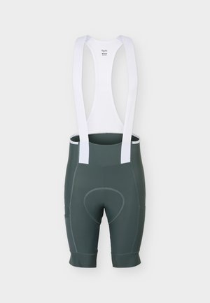 Pantaloni scurți de ciclism cu bretele, de culoare verde închis, cu bretele elastice albe pentru umeri și zonă tampoane la șezut, văzuți din spate pe un fundal simplu.