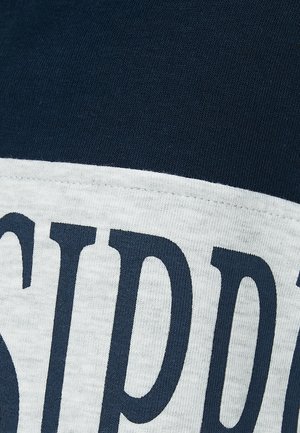 Marine blauwe en lichtgrijze shirt met korte mouwen, voorzien van vetgedrukte donkerblauwe tekst. Zacht, glad katoen met een contrasterende horizontale band.