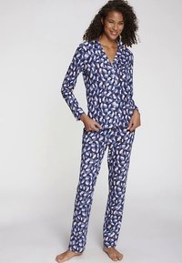 Ensemble de pyjama à motifs bleu marine et blanc comprenant un haut boutonné et un pantalon long, confectionné en tissu doux avec une texture lisse.