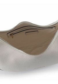 Interno di borsa in pelle bianca con trama, con chiusura a zip, dotato di una piccola tasca con zip e un'etichetta del marchio. Fodera liscia beige.