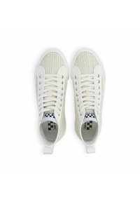 Białe trampki z tekstylną, plecioną cholewką, płaskimi sznurowadłami i solidną gumową podeszwą. Wewnątrz widoczne jest logo z wzorem w kratkę.