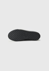Suola di scarpa in gomma nera con un motivo tessuto testurizzato. Presenta un logo CK in rilievo. Design piatto e leggermente arrotondato per il comfort.
