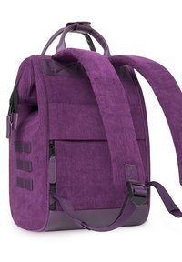 Zaino in velluto a coste viola con spallacci regolabili, più tasche esterne e un bordo inferiore liscio. Dotato di una robusta maniglia superiore.
