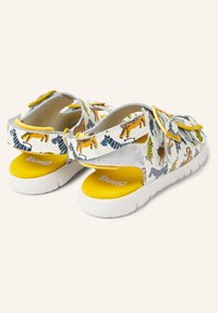White and yellow children's sandals with multicolored tiger patterns, adjustable straps, and thick white soles on a plain background.