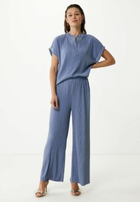 Conjunto de dos piezas en azul claro, con top sin cuello y pantalones de pierna ancha. Textura suave y ajuste relajado con cintura elástica.