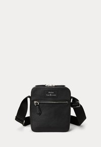 Musta teksturoidusta nahasta valmistettu olkalaukku, jossa vetoketjutasku edessä ja säädettävä kangashihna, jossa Polo Ralph Lauren -logo.