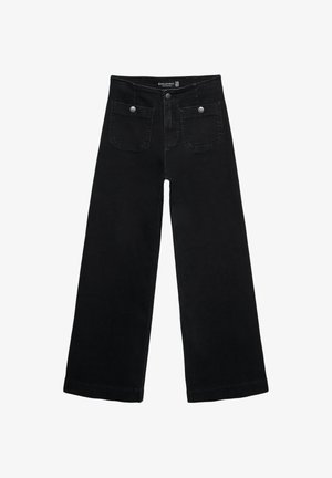Jean's larges noires avec taille haute, dotés de deux poches avant et d'accents en métal sur les boutons. Le tissu a une texture lisse.