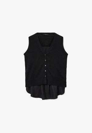 Zwart mouwloos vest met V-hals, knoopsluiting, zachte brei textuur, laagjes over een zwart satijnen blouse met een iets langere zoom.