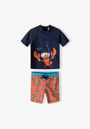 Haut de maillot de bain à manches courtes bleu marine avec un graphique de homard et le texte "PRÊT POUR LA PLAGE", associé à un short de bain orange orné de homards bleus.