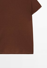 Brun kortærmet t-shirt lavet af blødt bomuld. Har en rund halsudskæring og lige kant med pæne syninger.