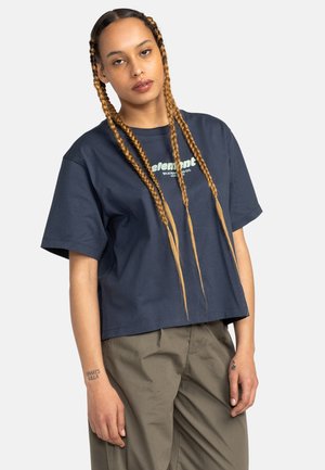 Navy blue cropped t-shirt in cotton with short sleeves featuring a white "Element" logo. Worn with light khaki pants, minimalistic design.