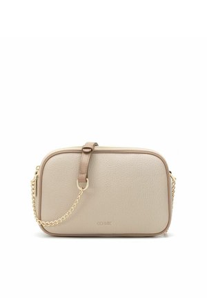 Beżowa, teksturowana skórzana torba na ramię o zaokrąglonych krawędziach, z złotym łańcuszkowym paskiem i małą skórzaną klamrą na przodzie.