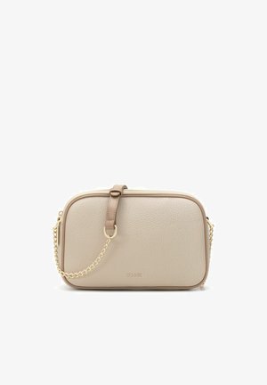 Beżowa, teksturowana skórzana torba na ramię o zaokrąglonych krawędziach, z złotym łańcuszkowym paskiem i małą skórzaną klamrą na przodzie.