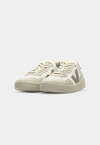 Hvite og beige sneakers med en blanding av lær og semsket skinn, avrundet tå, teksturerte detaljer og kontrasterende sidemotiv. Flat gummisåle.