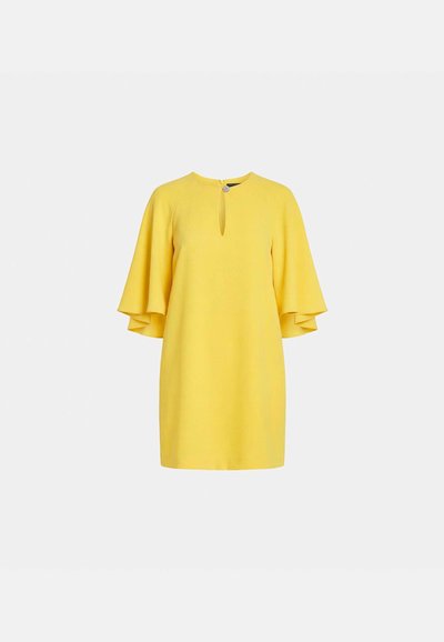 Robe jaune vif longueur genou avec manches évasées trois quarts, encolure ronde et petite ouverture en forme de goutte à l'avant avec fermeture à bouton.