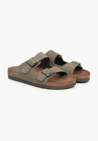 Grijze suede slide sandalen met twee verstelbare banden met metalen gespen, een kurken middenzool en een geprofileerde rubberen buitenzool.