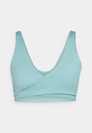 Weiche teal-farbene Bralette mit V-Ausschnitt, nahtlosen Konturen und gewickeltem Vorderteil. Hergestellt aus dehnbarem Stoff für zusätzlichen Komfort.