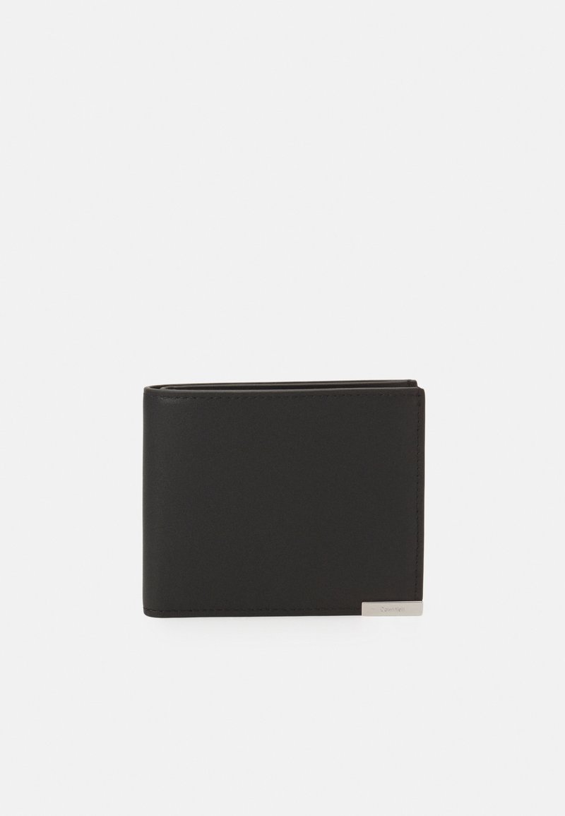 Portafoglio in pelle nera con superficie liscia, design a due pieghe e un dettaglio metallico nell'angolo in basso a destra.