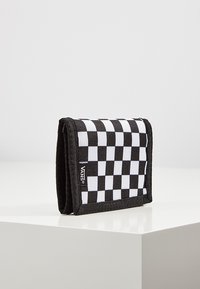 Portafoglio a scacchi bianco e nero in tessuto, con bordi cuciti, design pieghevole e etichetta con logo sul lato anteriore.