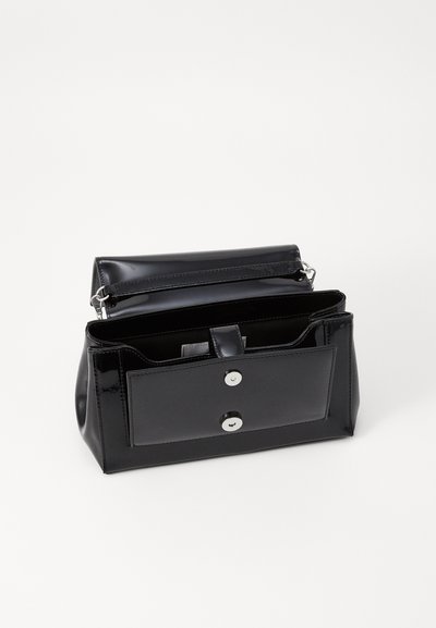 Bolsa de mão em verniz preto com uma forma estruturada, fecho de botão de pressão e alça ajustável. Possui compartimentos interiores para melhor organização.