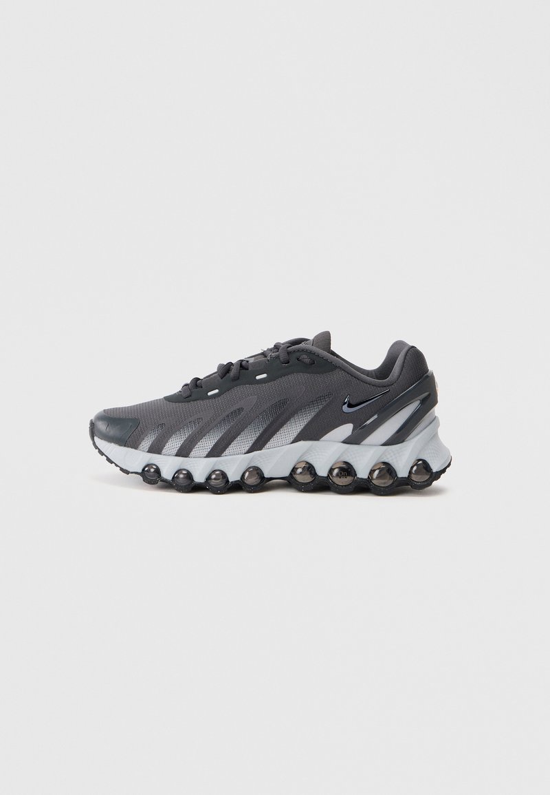 Crne i sive atletske tenisice s mrežastim gornjim dijelom, jedinstvenim dizajnom potplate u obliku mjehurića, crnim Nike swoosh logotipom i vezanjem na bijeloj pozadini.