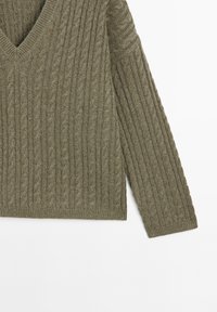 Olive green knit sweater with a V-neck, featuring a textured cable pattern and long sleeves, cropped length, soft material, and ribbed hem.