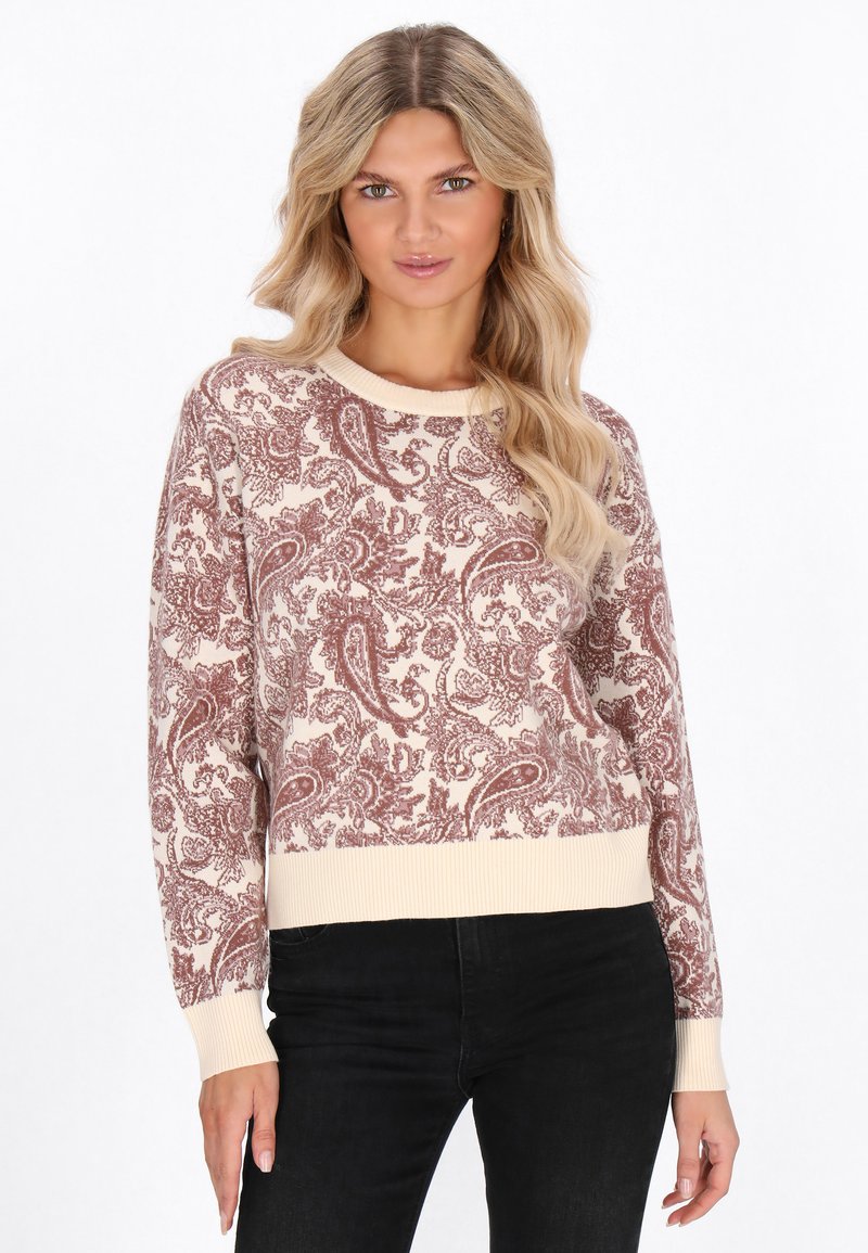 Pulover ușor crem cu un model paisley burgund. Guler și manșete cu riburi, design scurt. Asortat cu pantaloni negri.