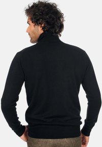 Schwarzer Strickpullover mit hohem Kragen, taillierter Passform, gerippten Bündchen und Saum, der eine glatte Textur und eine schlanke Silhouette zeigt.