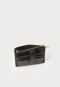 Portefeuille en cuir noir avec fermeture éclair, présentant un design plissé et un tirette dorée. Forme compacte et rectangulaire.